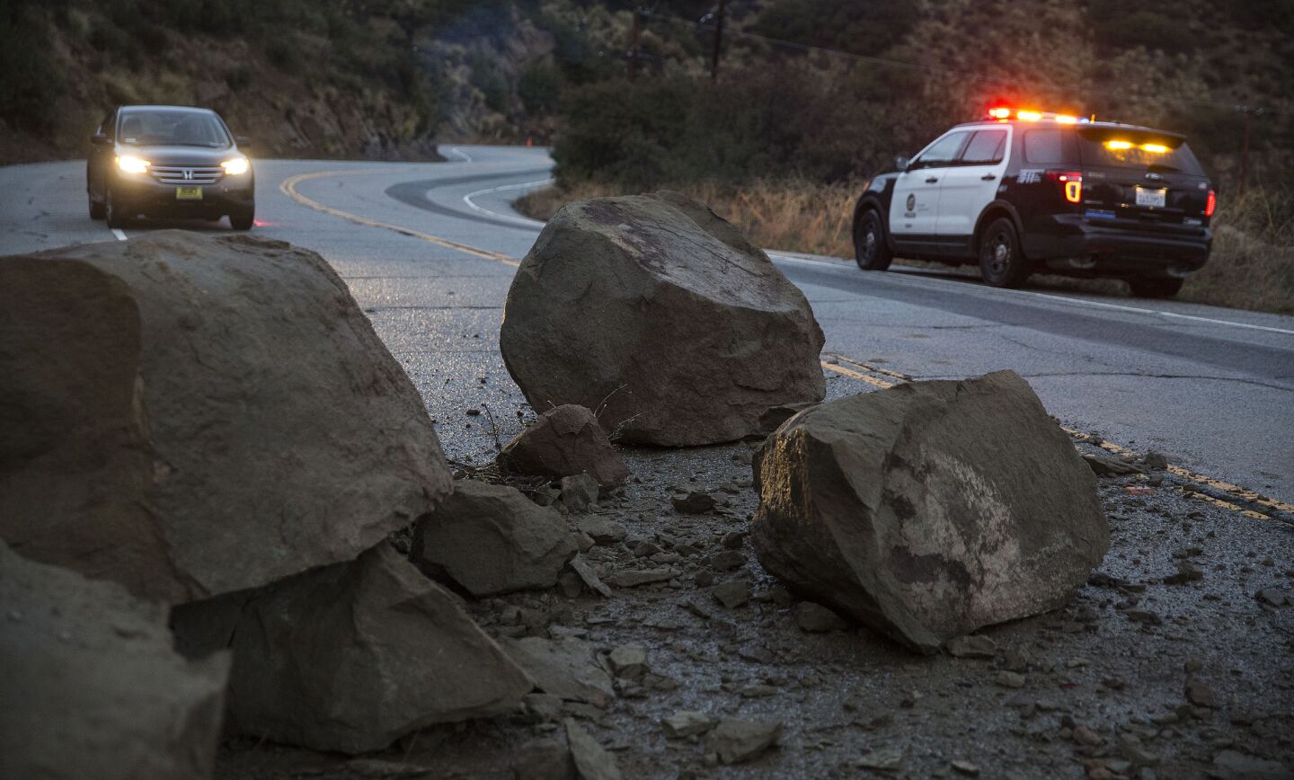 Large boulders block Santa Susanna Pass Rd. two miles west of Topanga Canyon after a rain-soaked hillside slid onto the roadway in Chatsworth.