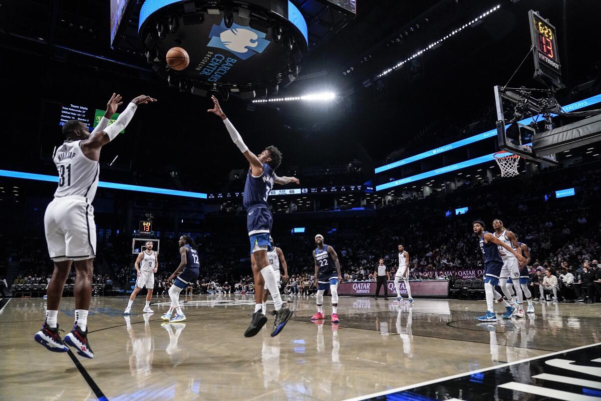 Brooklyn Nets' Paul Millsap (31) shoots a 3-pointer over Minnesota Timberwolves' Jaden McDaniels (3) during the second half of a preseason NBA basketball game Thursday, Oct. 14, 2021, in New York. (AP Photo/Frank Franklin II)