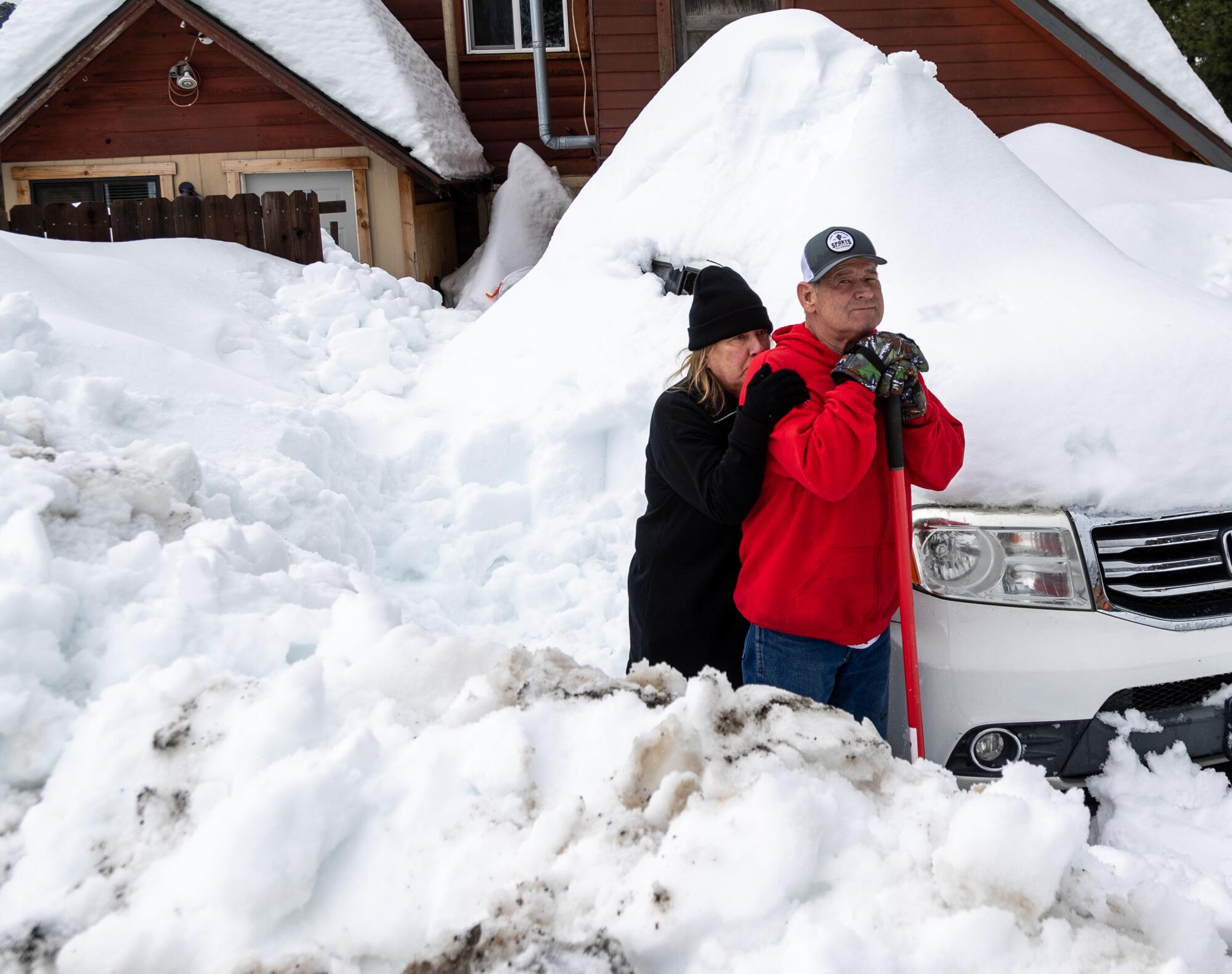Deanna Beaudoin leans on Don Kendrick while taking a break from shoveling out their car.
