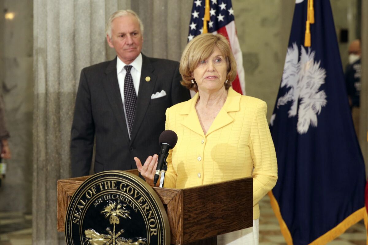 FILE - In this April 13, 2021, file photo, South Carolina Education Superintendent Molly Spearman speaks during a news conference as South Carolina Gov. Henry McMaster in Columbia, S.C. South Carolina students will again be required to wear masks on school buses starting Monday, Aug. 30, 2021, as COVID-19 cases among children and students are rising rapidly. Spearman said the delta variant of COVID-19 appears to be spreading quickly in children and more must be done to keep students safe and schools open. (AP Photo/Jeffrey Collins, File)