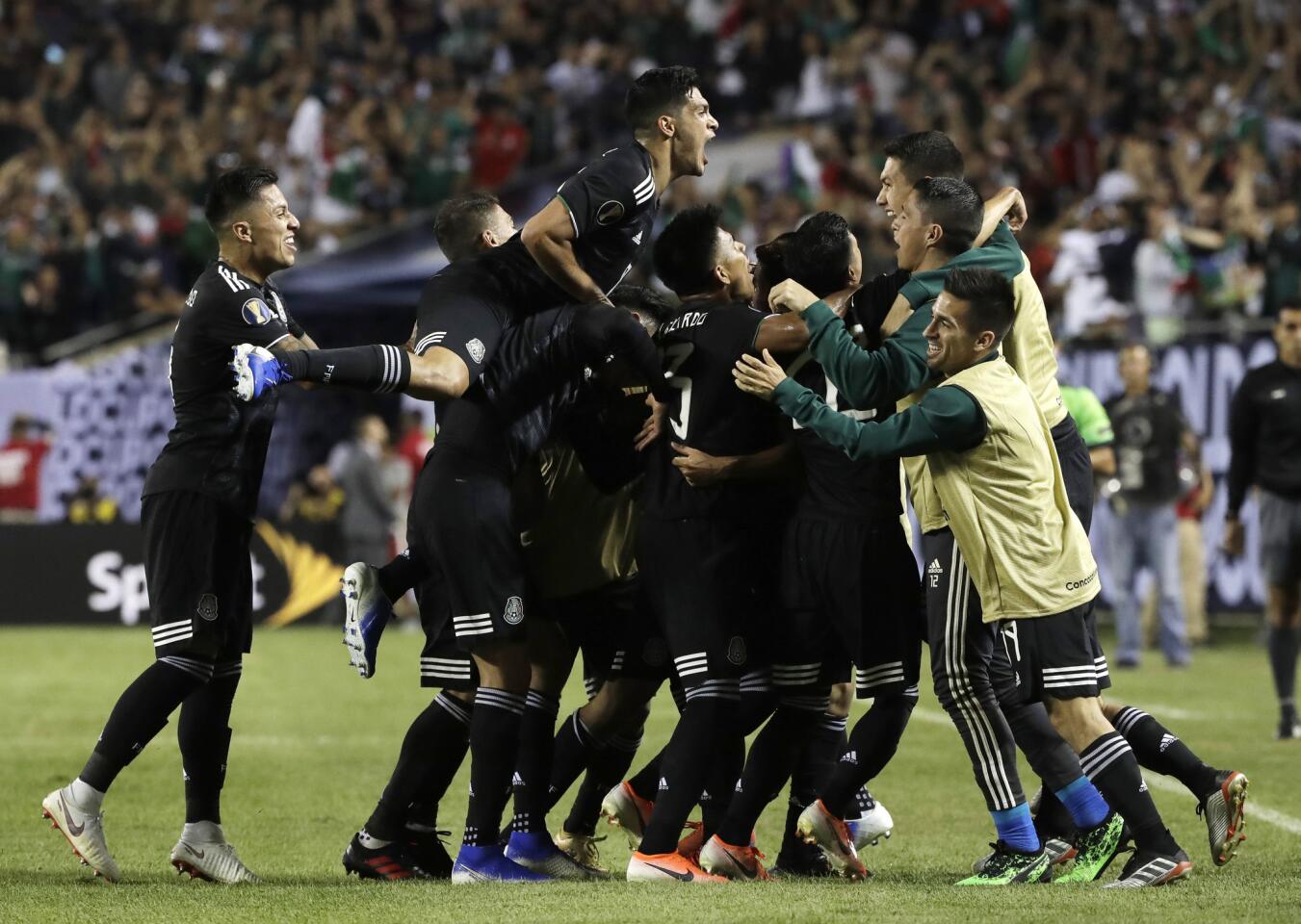 Mexico midfielder Jonathan Dos Santos (6) celebrates with teammates after scoring his first goal against the United States during the second half of the CONCACAF Gold Cup final soccer match in Chicago, Sunday, July 7, 2019.