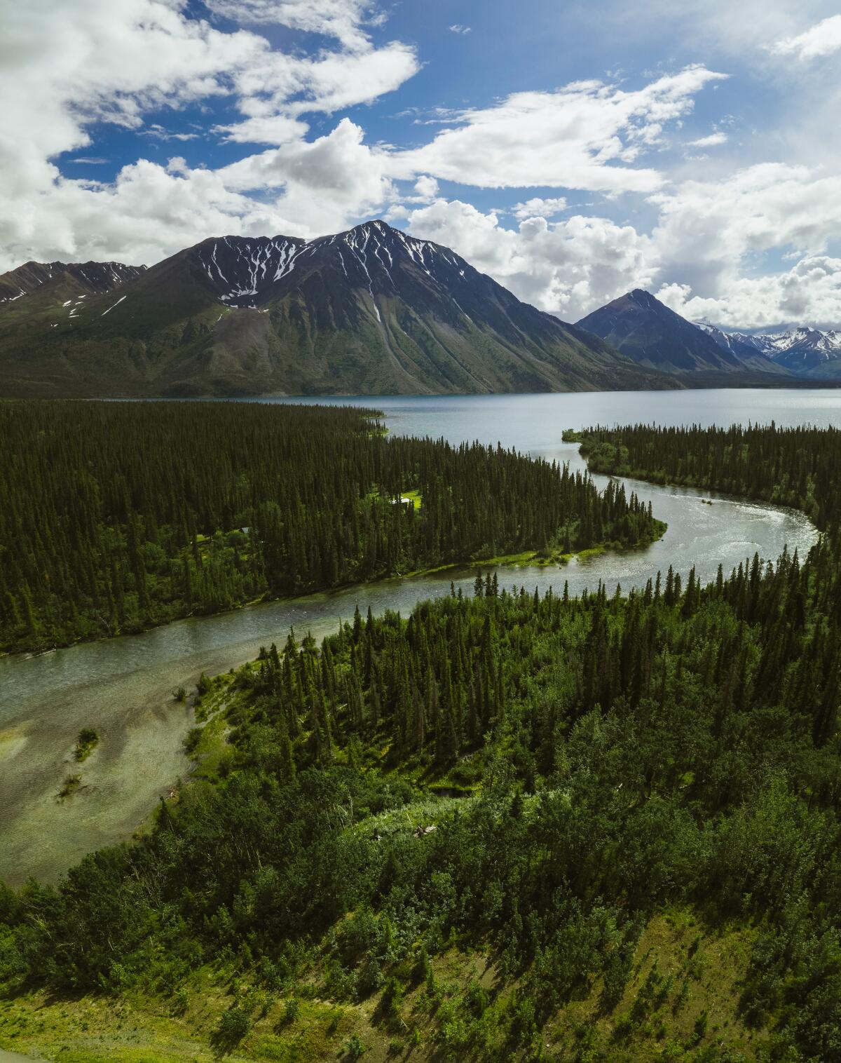A river winds through Kluane National Park and Reserve, home to 19,551-foot Mount Logan, the highest mountain in Canada.