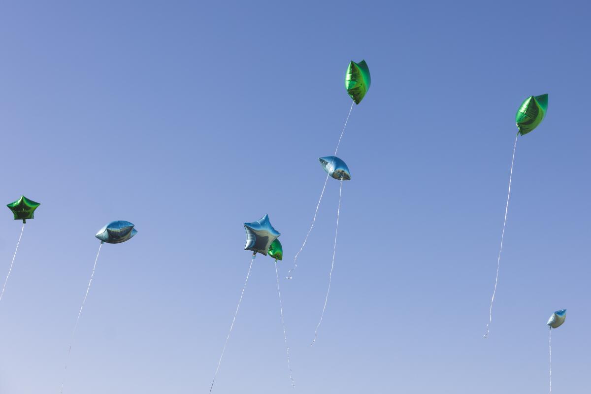 Balloons are released at a gravestone unveiling ceremony.