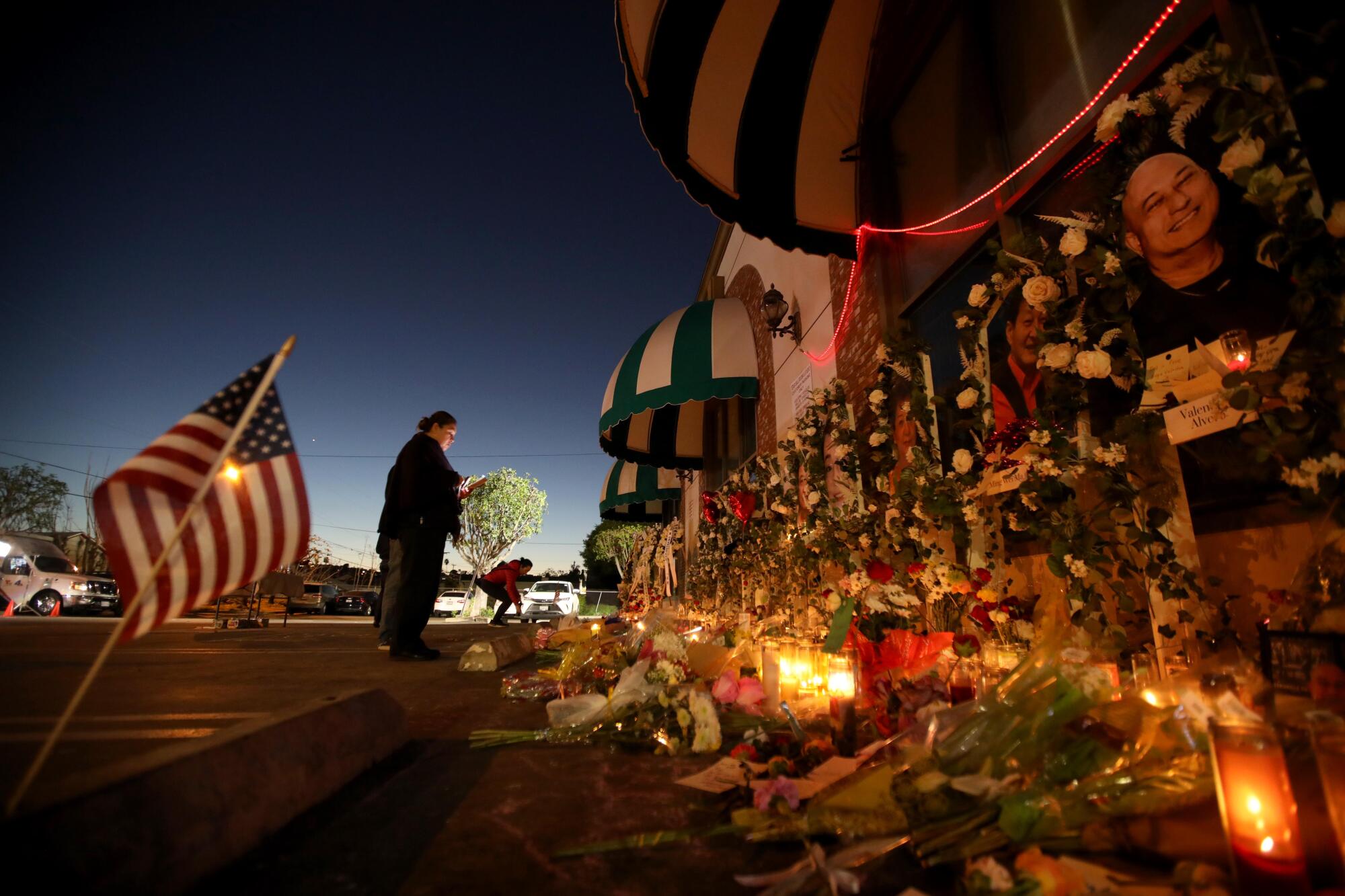 Flowers and candles at an outdoor memorial site 