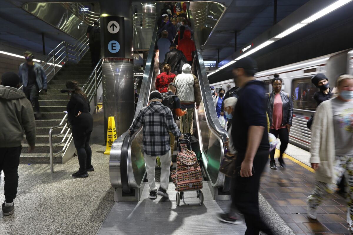 Commuters ride an escalator after departing a Metro train.