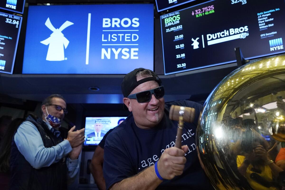 Dutch Bros. Coffee co-Founder and President Travis Boersma rings the ceremonial first trade bell on the floor of the New York Stock Exchange, as his company's IPO opens, Wednesday, Sept. 15, 2021. (AP Photo/Richard Drew)