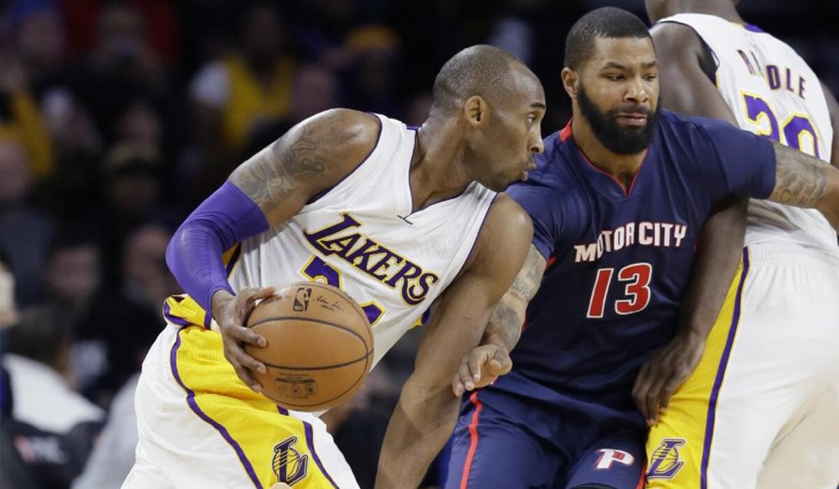 Lakers forward Kobe Bryant drives around Pistons forward Marcus Morris (13) during the first half.