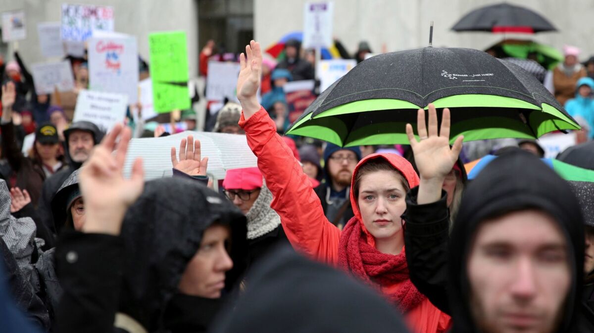 People raise their hands to signify #MeToo during the women's march Jan. 21 in Salem, Ore.