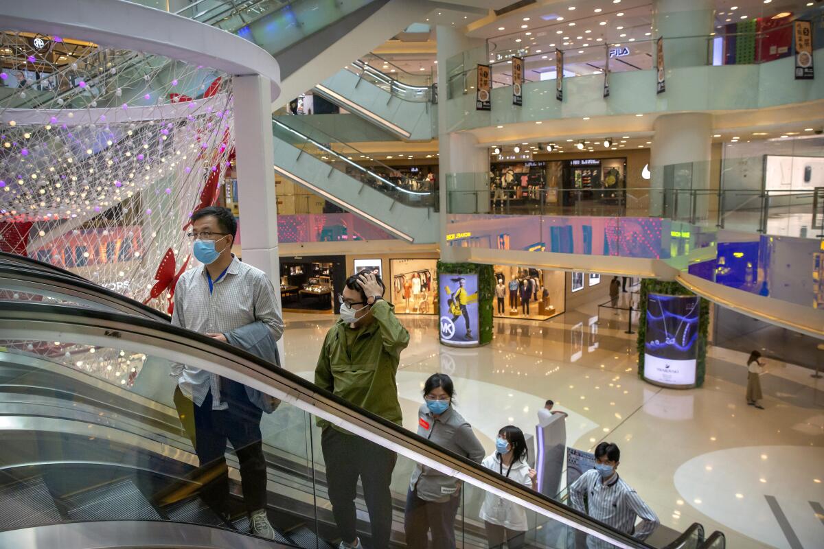 People wear face masks at a mall in Beijing