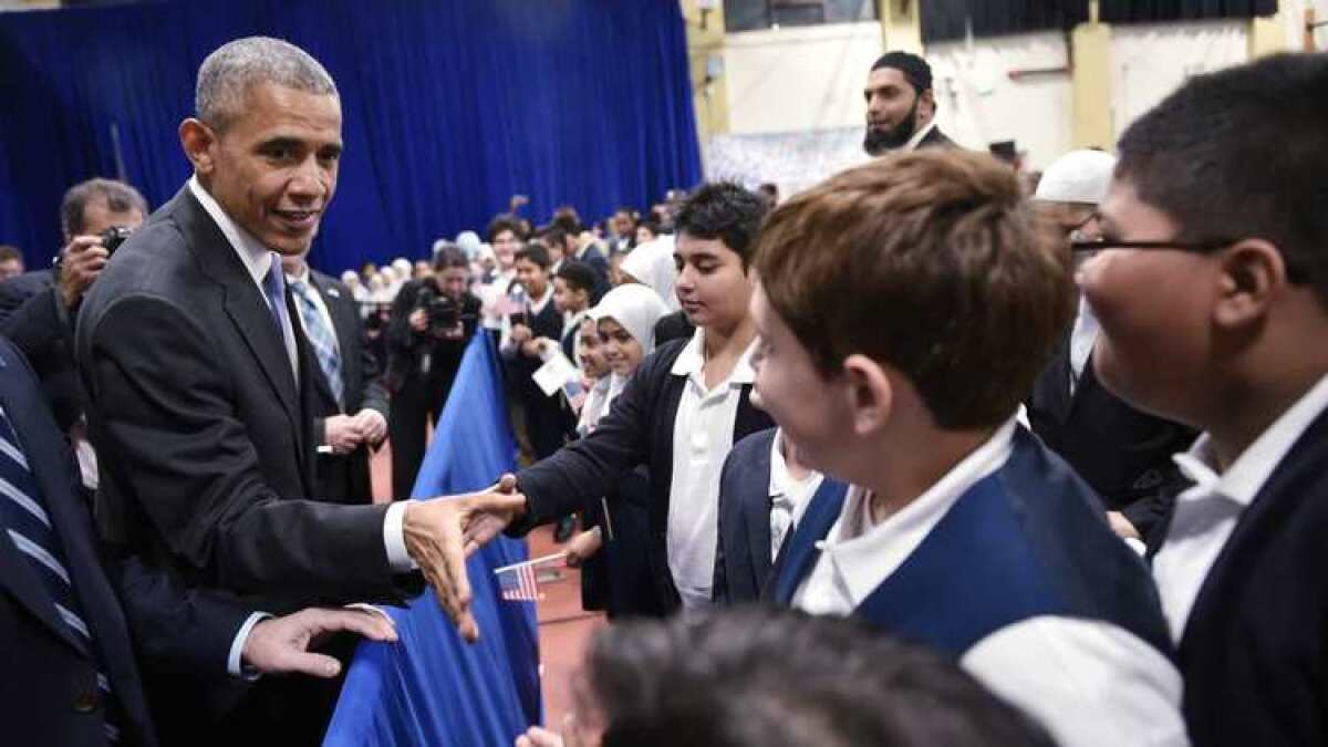 President Obama greets students earlier this week at a Baltimore mosque, where he offered the kind of upbeat message he hopes fellow Democrats will embrace — especially on the campaign trail.