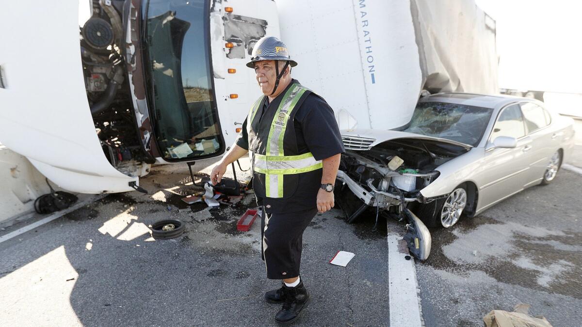 Joe Acosta from Pepe's Towing sizes up the extraction of a car and a box truck tangled with each other at the southbound Golden State (5) Freeway exit at Burbank Boulevard on Thursday. Minor injuries occurred with a backup in southbound lanes extending to Glenoaks Boulevard.
