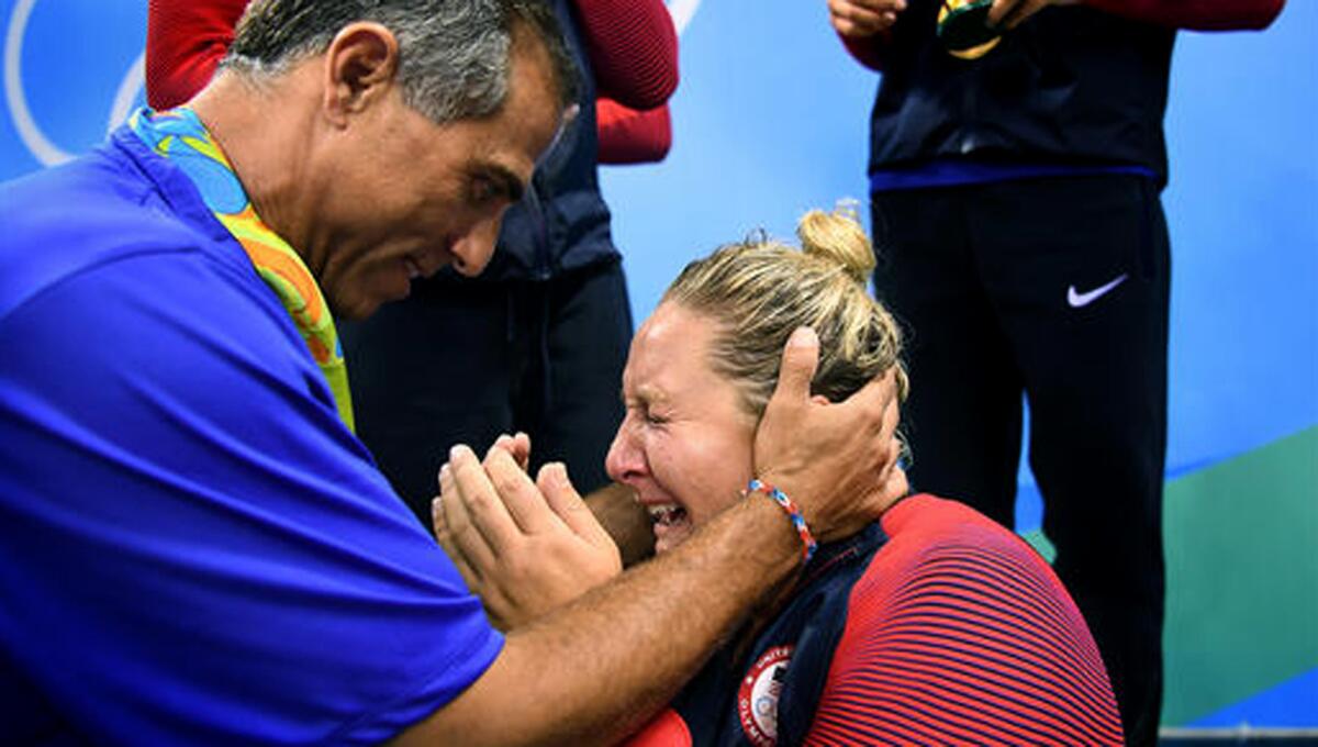 Women's water polo Coach Adam Krikorian consoles team star Melissa Seidemann, whose mother became ill shortly after arriving in Brazil and wasn't in attendance when the U.S. women won the gold medal.
