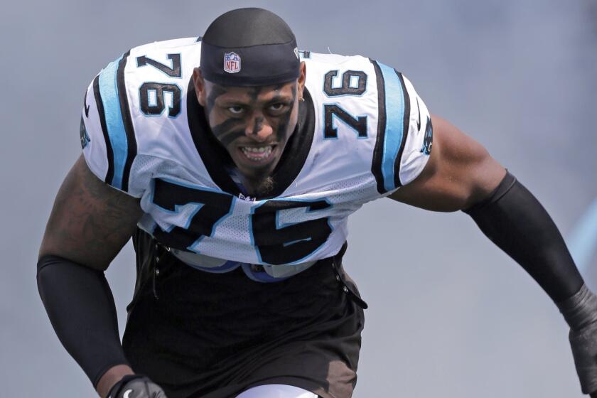 Greg Hardy, then a defensive end for the Carolina Panthers, runs onto the field during player introductions before a game in September 2013. Hardy signed with the Cowboys in March.