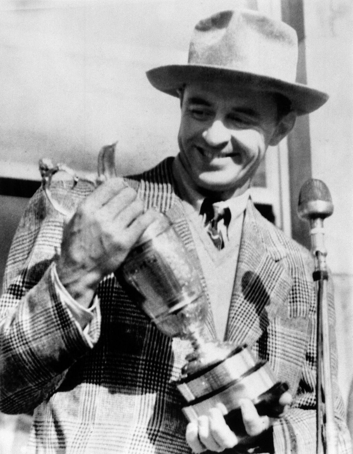 FILE - In this July 5, 1946, file photo, Sam Snead, holds the British Open Golf Championship Trophy he won at St. Andrews, Scotland with a 72-hole score of 290. Snead, who won 75 years ago, did not return to the British Open until 1962. (AP Photo/File)