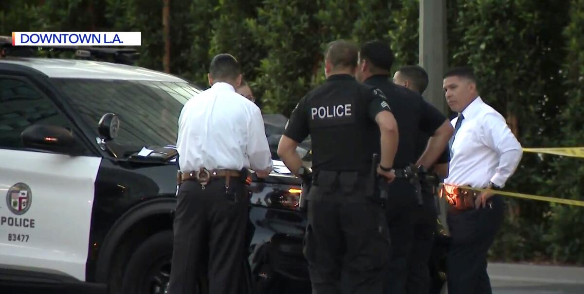 Police officers and investigators outside an LAPD SUV