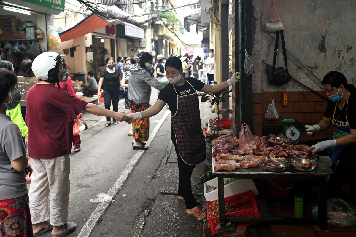 Shoppers practice social distancing at a market in Hanoi, Vietnam, on Sunday.