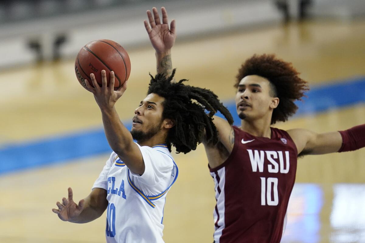 UCLA guard Tyger Campbell shoots against Washington State guard Isaac Bonton.