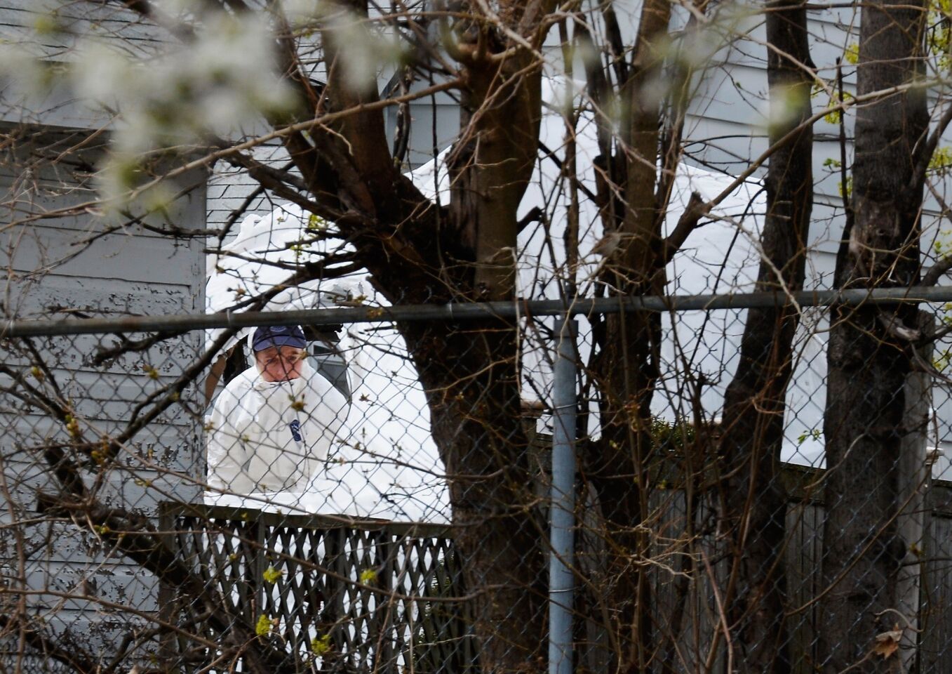 An FBI investigator wearing white overalls stands inside the boat where the bombing suspect was hiding from police on Franklin Street in Watertown, Mass. A manhunt for suspect Dzhokhar A. Tsarnaev, 19, ended Friday after he was apprehended on the boat. His brother Tamerlan Tsarnaev, 26, the other suspect, was shot and killed after a car chase and shootout with police.