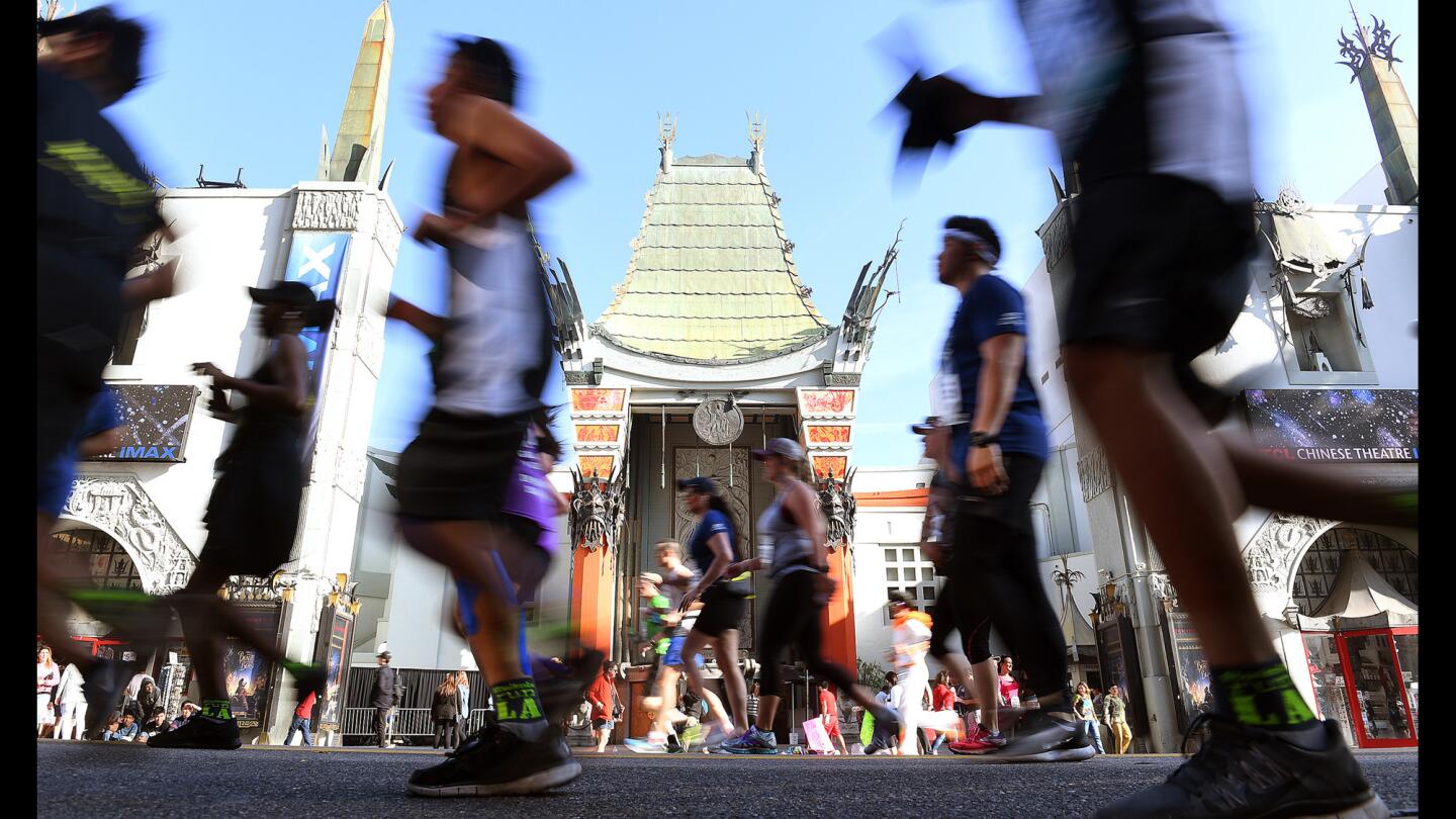 Race participants pass by Grauman???s Chinese Theatre during the LA Marathon.