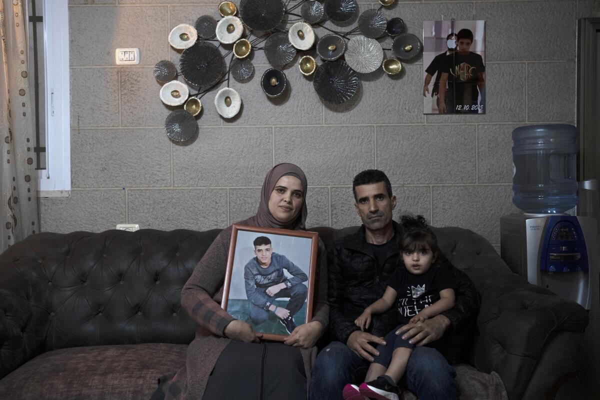 Palestinian couple holding portrait of their imprisoned son