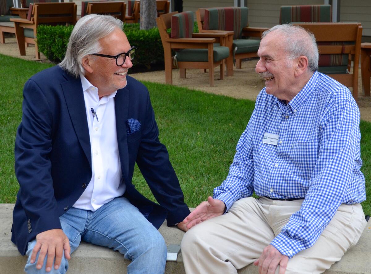Mike Zimmerman, president of Friends of OASIS Senior Center, talks with treasurer Howard Herzog.