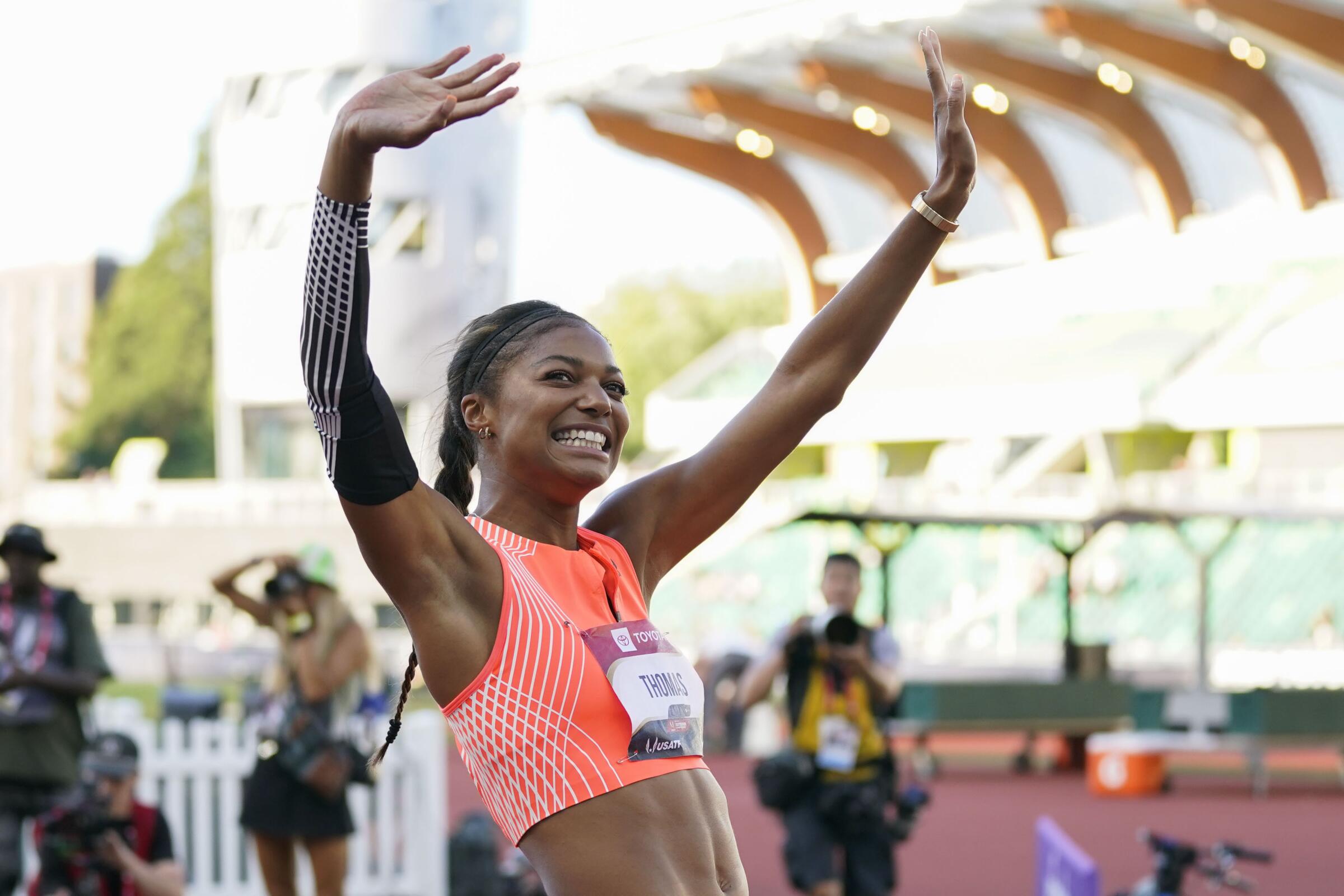 Gabby Thomas waves to spectators after winning the gold medal in the 200-meter dash at the U.S. track and field championships