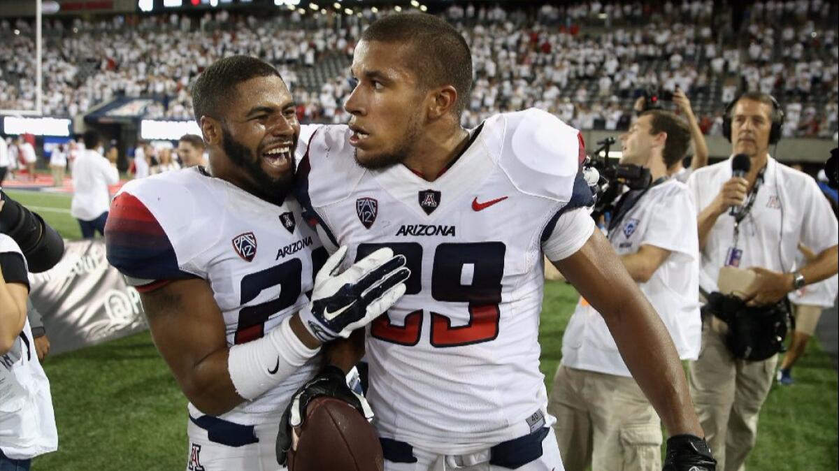 Arizona receiver Austin Hill (29) celebrates with a teammate after catching a game-winning, 47-yard touchdown pass against California on Sept. 20, 2014.