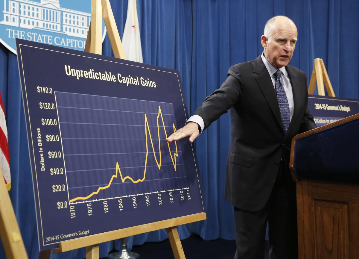 Gov. Jerry Brown points to a chart showing the volatility of capital gains revenues that the state depends on for budgeting, during a news conference where he unveiled his proposed 2014-15 state budget in Sacramento on Thursday.
