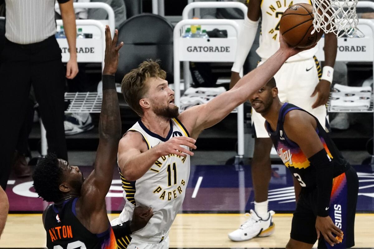 Indiana Pacers forward Domantas Sabonis (11) drives past Phoenix Suns center Deandre Ayton (22) during the first half of an NBA basketball game Saturday, March 13, 2021, in Phoenix. (AP Photo/Rick Scuteri)