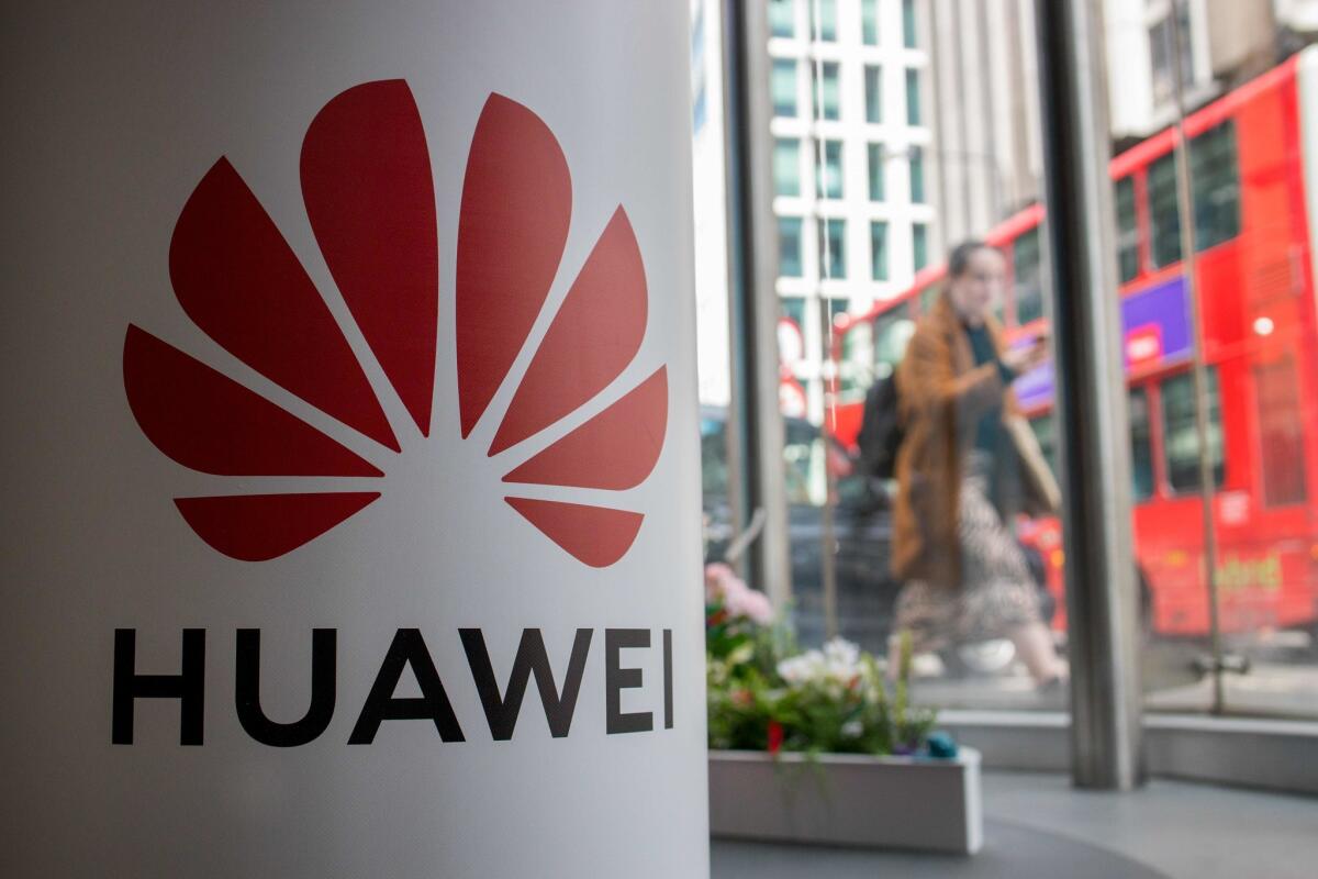 A pedestrian walks past a Huawei product stand at a telecommunications shop in central London.