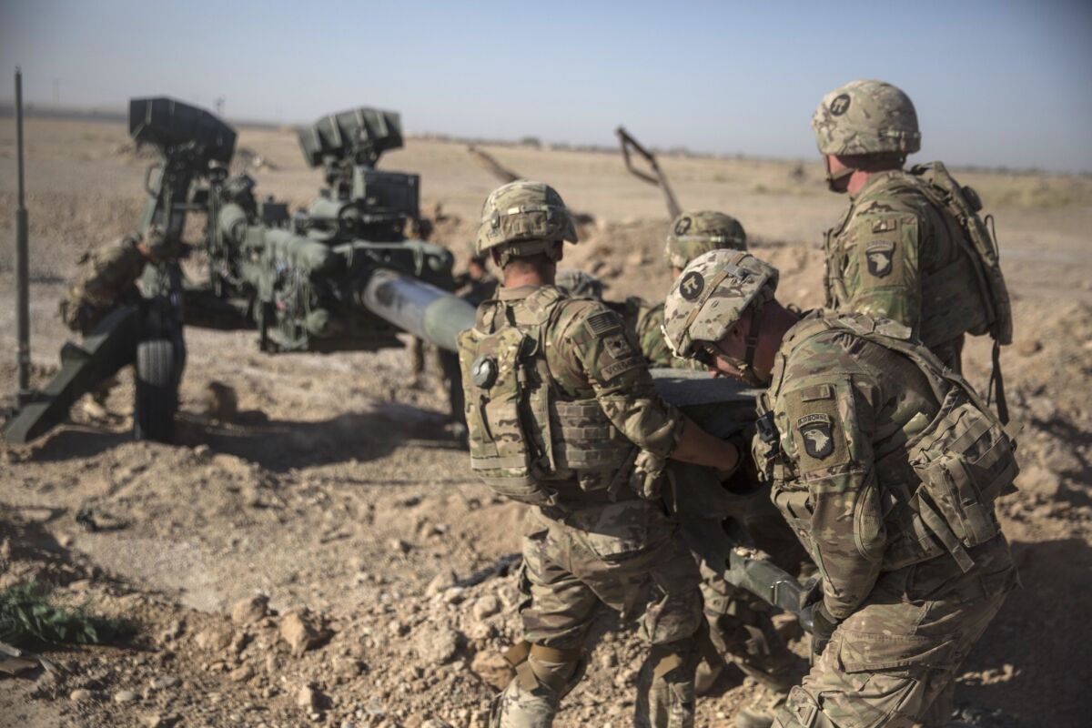 In this June 10, 2017 photo provided by Operation Resolute Support, U.S. Soldiers with Task Force Iron maneuver an M-777 howitzer, so it can be towed into position at Bost Airfield, Afghanistan.