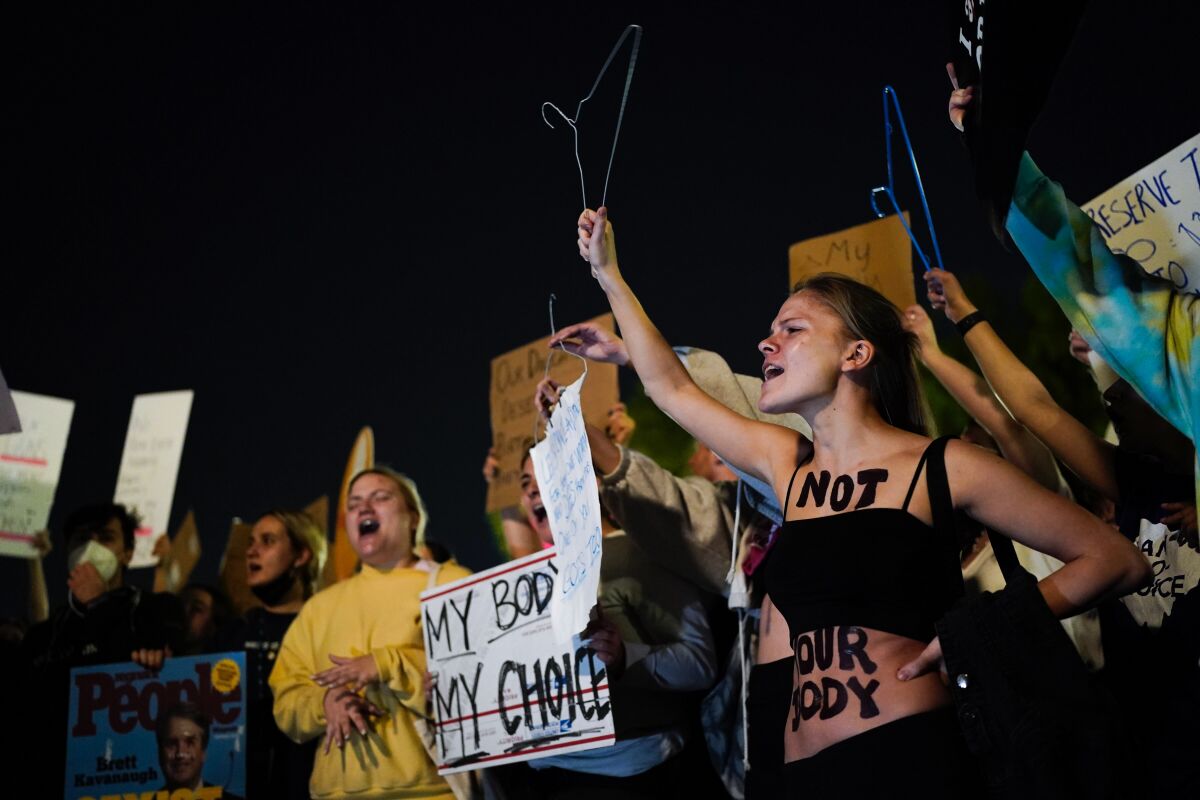 A crowd gathers outside the Supreme Court on Monday night .