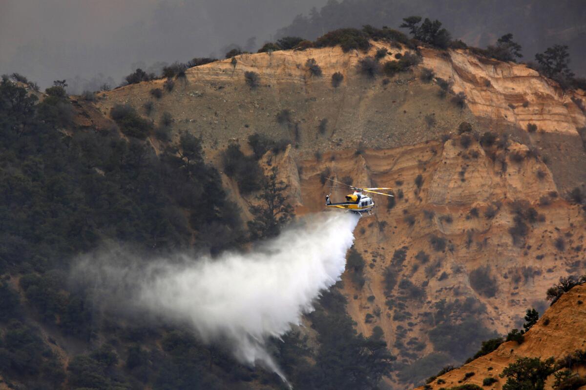 A firefighting helicopter makes a drop on the Grand fire burning in Kern County.