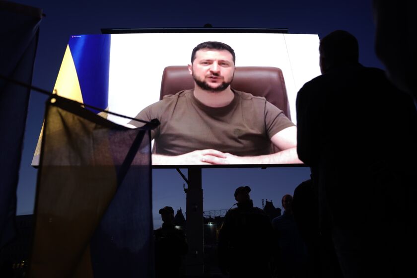 People gather to watch Ukrainian President Volodymyr Zelenskyy speak on a screen at the City Hall Square in Copenhagen