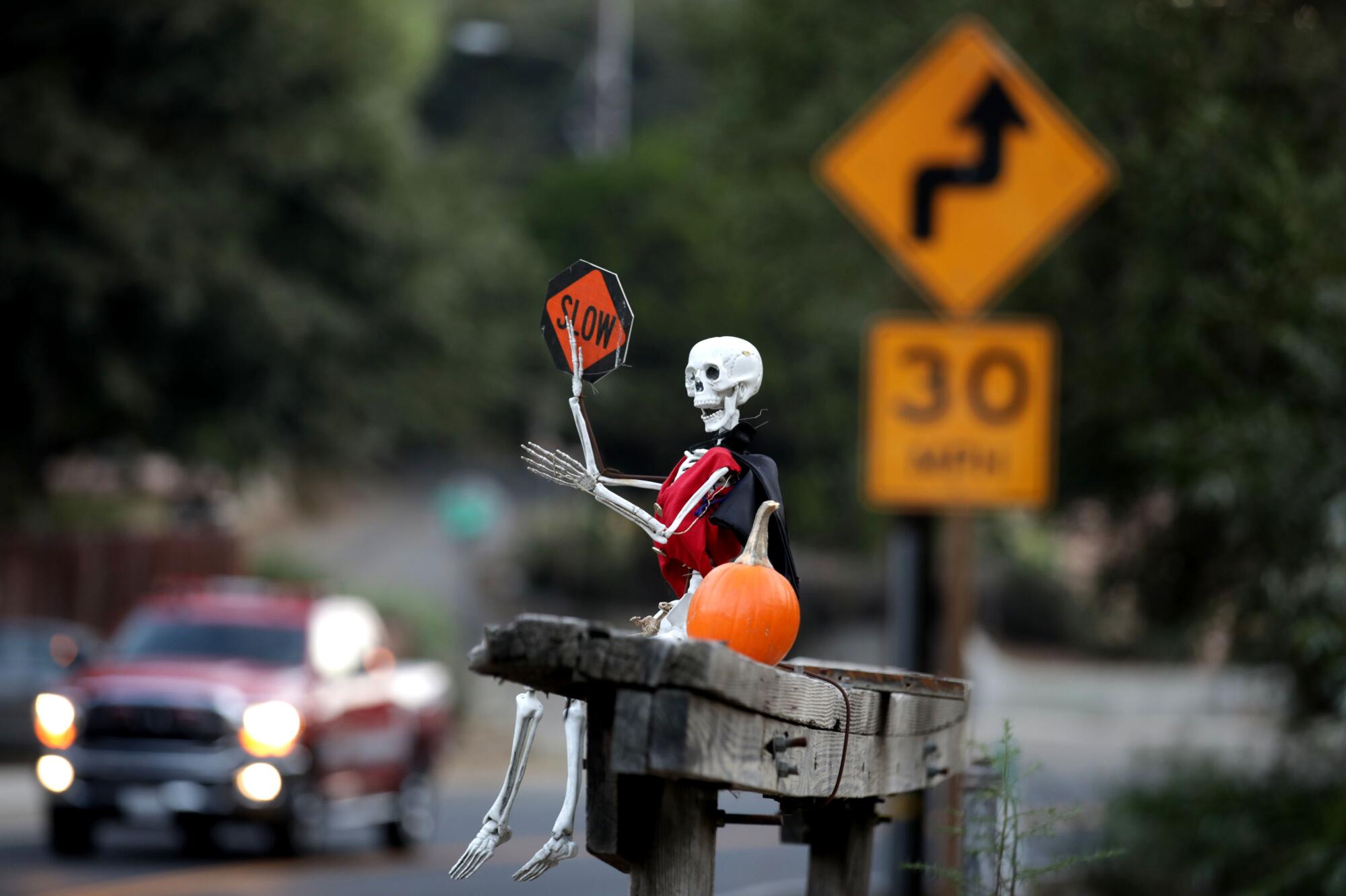 A skeleton perched on a bench encourages motorists to slow down near the Sleepy Hollow community on Carbon Canyon Road