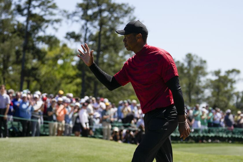Tiger Woods waves to spectators on the 18th green after his final round at the Masters golf tournament on Sunday, April 10, 2022, in Augusta, Ga. (AP Photo/Jae C. Hong)