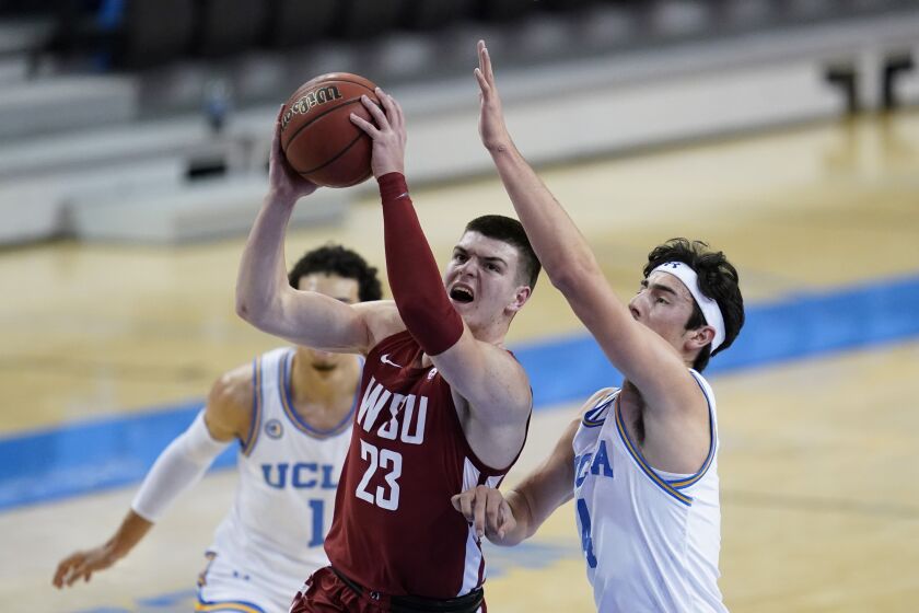 Washington State forward Andrej Jakimovski (23) takes a shot against UCLA guard Jaime Jaquez Jr., right, during the first half of an NCAA college basketball game Thursday, Jan. 14, 2021, in Los Angeles. (AP Photo/Ashley Landis)