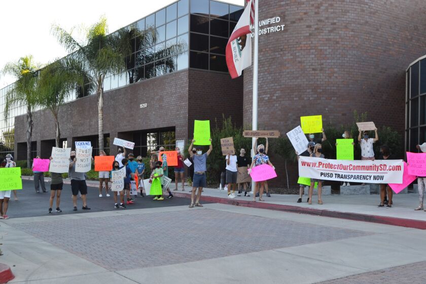 Community members gather outside the district office on Oct. 15 to protest the potential lease of a parcel of district land to Costco.