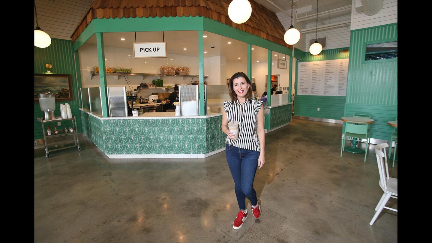 Owner Poppy Holguin walks through the spacious dining room of Jan's Health Bar, which will celebrate its 45th anniversary with a party at the Huntington Beach location on March 25th.