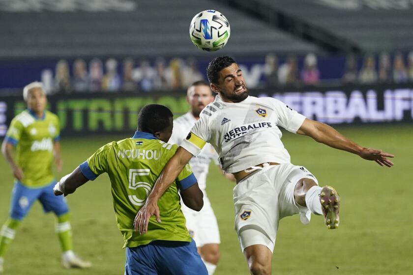 LA Galaxy midfielder Sebastian Lletget, right, heads the ball next to Seattle Sounders defender Nouhou Tolo during the first half of an MLS soccer match Wednesday, Nov. 4, 2020, in Carson, Calif. (AP Photo/Ashley Landis)