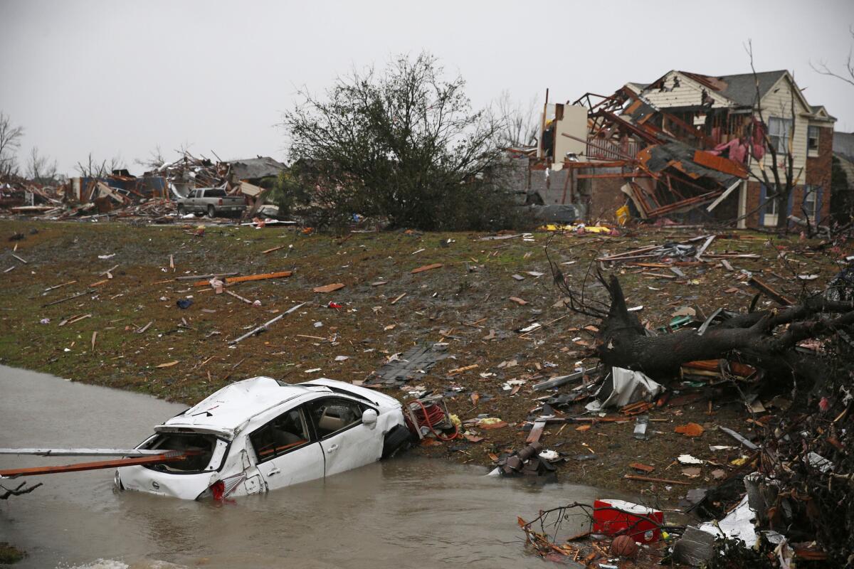 A car is flooded in a drainage ditch on Sunday after a tornado hit Rowlett, Texas.