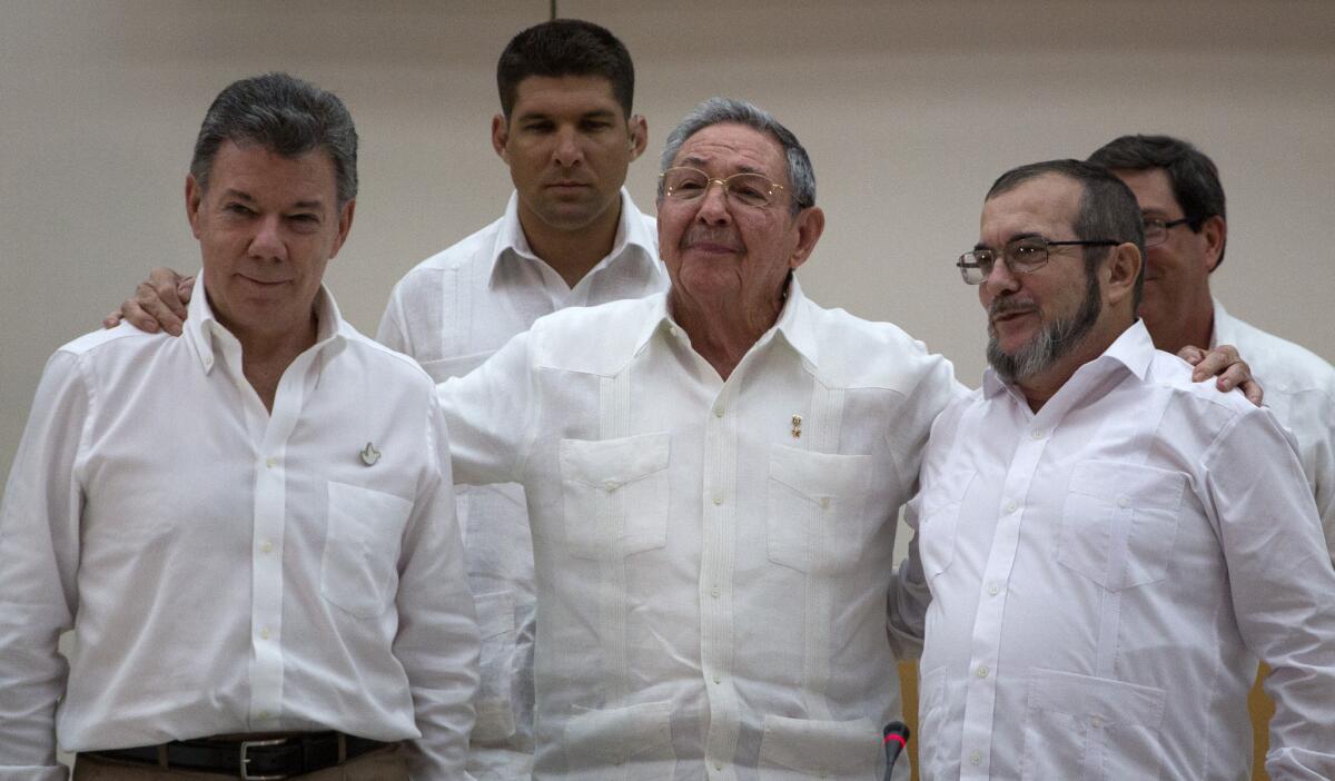 Cuba's President Raul Castro, center, stands with Colombian President Juan Manuel Santos, left, and the commander of the Revolutionary Armed Forces of Colombia, or FARC, Timoleon Jimenez, in Havana on Sept. 23, 2015.