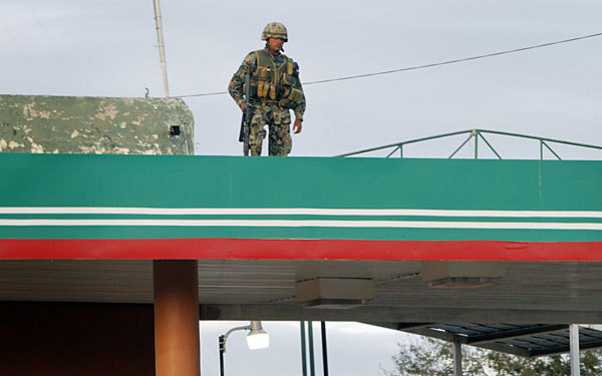A Mexican soldier watches a key intersection that leads directly to the U.S. outside the Mexican city of Reynosa in 2010.