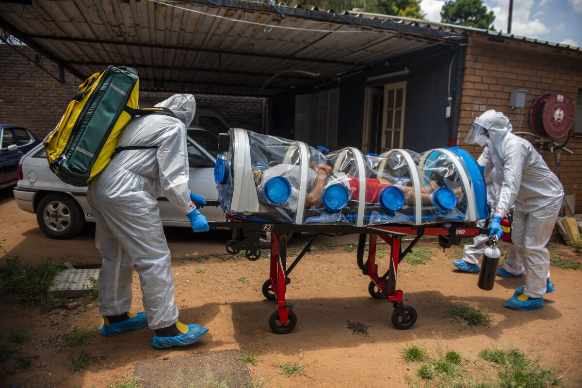 Members of the Tshwane Special Infectious Unit on COVID-19 wearing personal protective equipment pick up a patient.