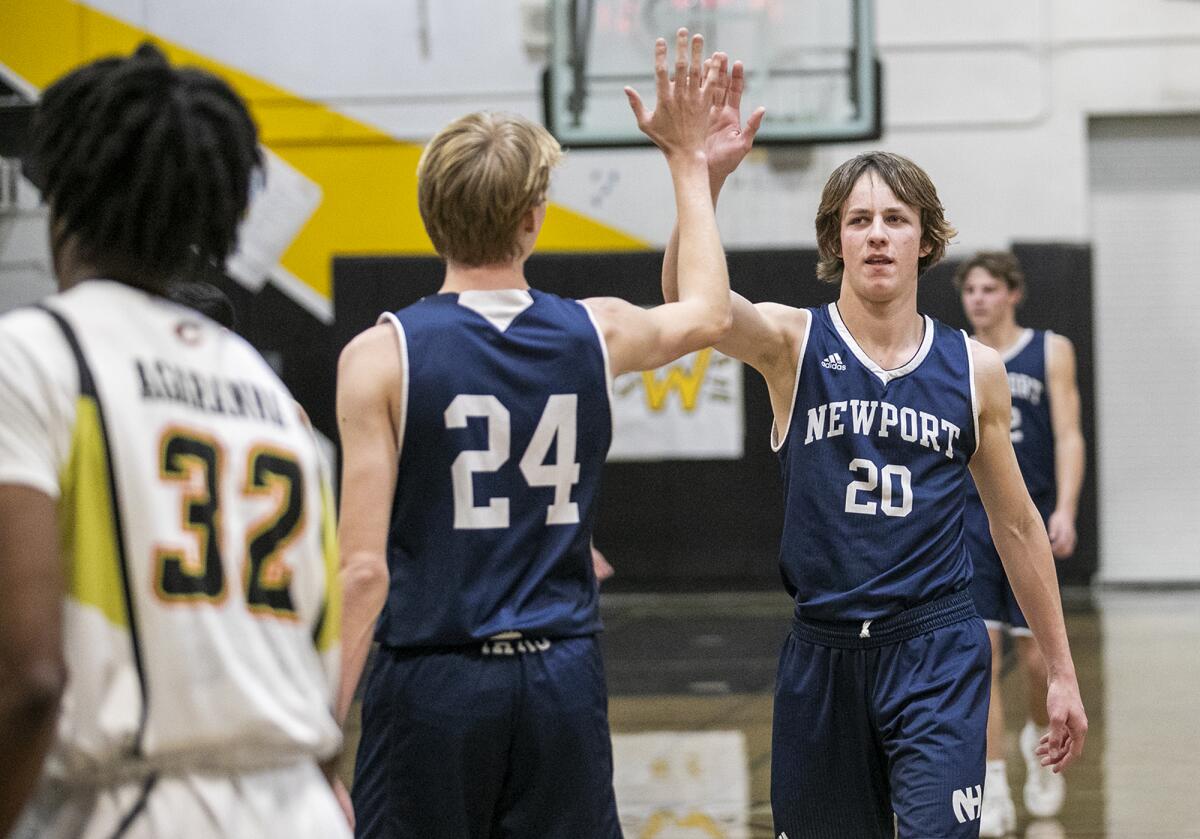 Newport Harbor's Adam Gaa, left, high fives Dashiell Bastedo during a playoff game against Cerritos on Friday.