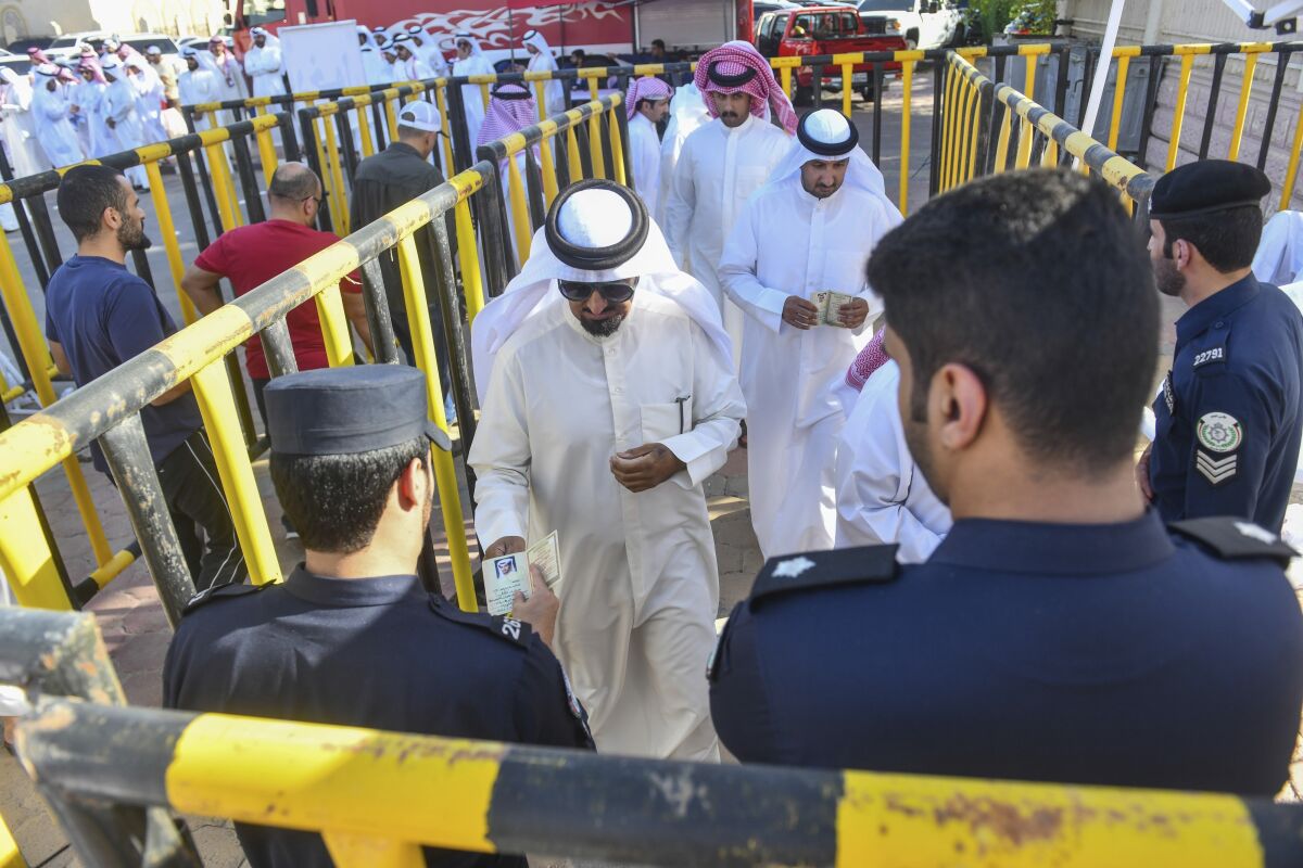 People stand in line to cast their votes for National Assembly elections in Salwa district, Kuwait, Thursday, Sept. 29, 2022. (AP Photo/Jaber Abdulkhaleg)