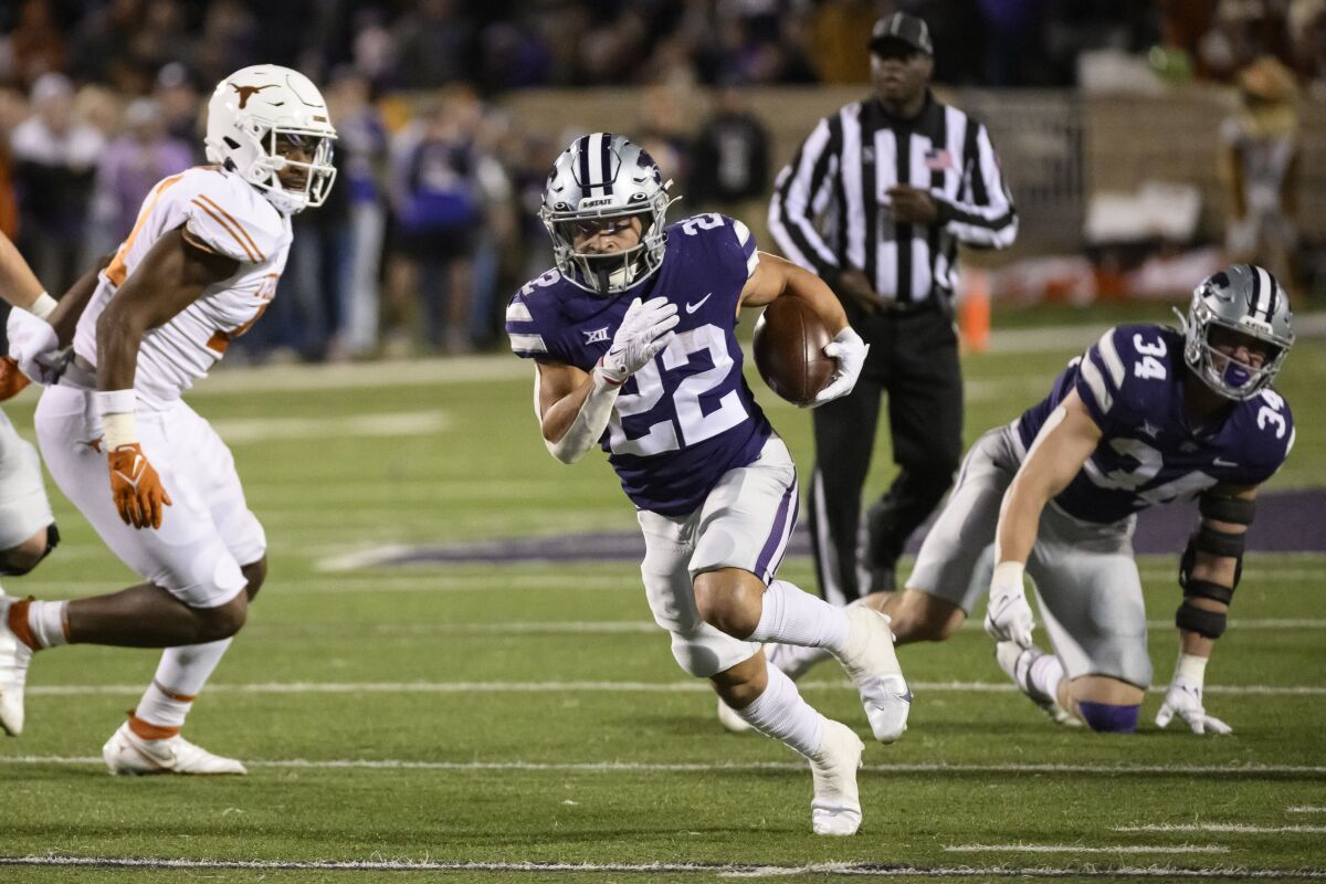 FILE - Kansas State running back Deuce Vaughn (22) carries the ball against Texas during the second half of an NCAA college football game Saturday, Nov. 5, 2022, in Manhattan, Kan. The body types are certainly much different for TCU's Kendre Miller and Kansas State's 5-foot-6 dynamo Deuce Vaughn. And yet the running backs that will be featured in the Big 12 championship game look pretty similar in what they do on the field. (AP Photo/Reed Hoffmann, File)