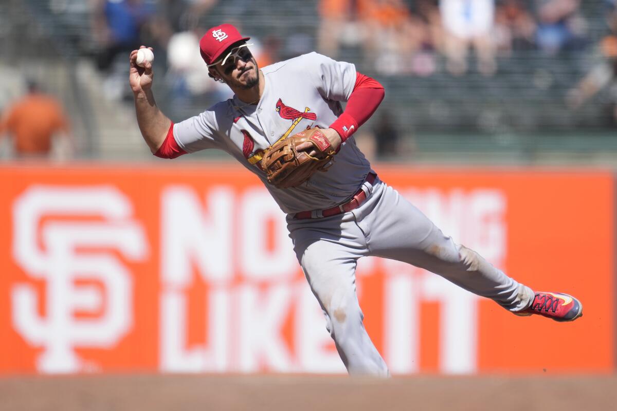 Cardinals third baseman Nolan Arenado throws a ball while falling to his right.
