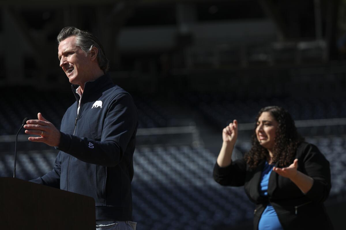 California Governor Gavin Newsom speaks to members of the media during a press conference at Petco Park on Monday.