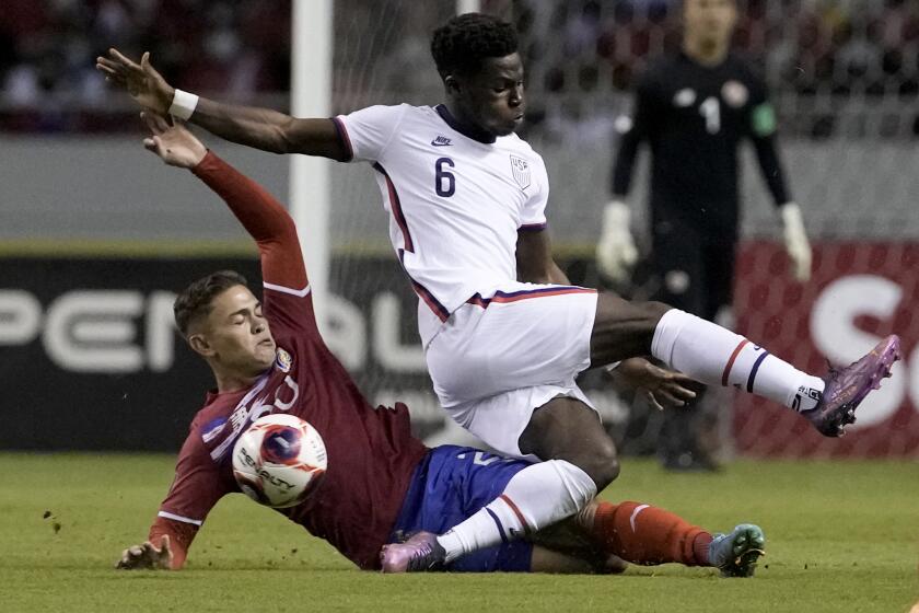 Costa Rica's Brandon Aguilera, below, and United States' Yunus Musah battle for the ball during a qualifying soccer match for the FIFA World Cup Qatar 2022 in San Jose, Costa Rica, Wednesday, March 30, 2022. (AP Photo/Moises Castillo)